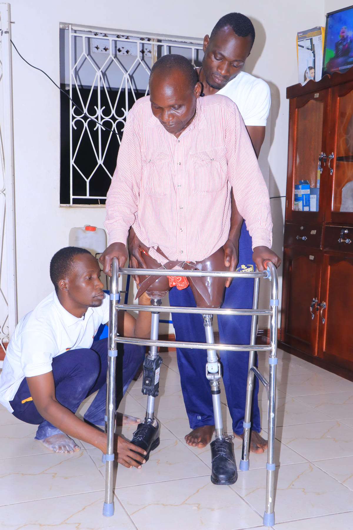 Patient being assisted by Dr. Nelson Mubiru at Nkolo Orthopaedics Rehabilitation Center (NORC)