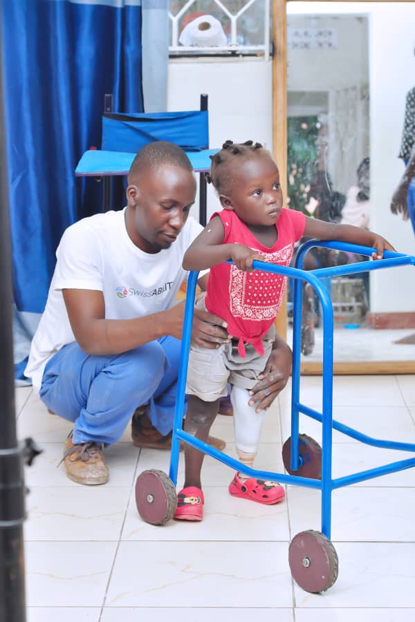 Patient being assisted by Dr. Nelson Mubiru at Nkolo Orthopaedics Rehabilitation Center (NORC)