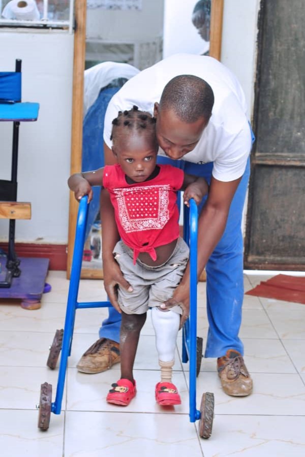 Patient being assisted by Dr. Nelson Mubiru at Nkolo Orthopaedics Rehabilitation Center (NORC)