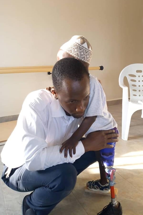 Patient being assisted by Dr. Nelson Mubiru at Nkolo Orthopaedics Rehabilitation Center (NORC)